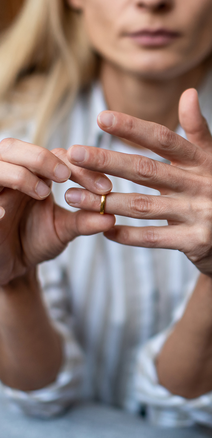 Divorce proceedings for Polish citizens in the UK Woman removing wedding ring, symbolising divorce and family law cases among Poles in the UK